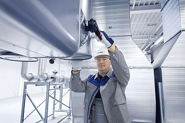 Leadec employee working on the ventilation system of a factory.