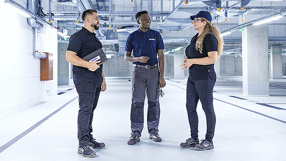 Leadec-Team im Gespräch in einem technischen Bereich.
