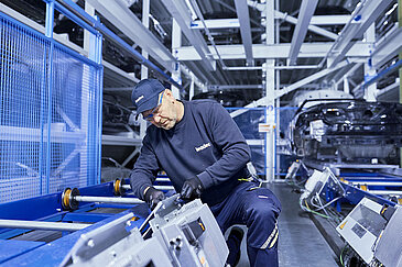 A Leadec employee replacing an inverter at a conveyor belt.